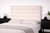 Bedroom with a bed featuring a beige upholstered headboard, white bedding, and black nightstands.