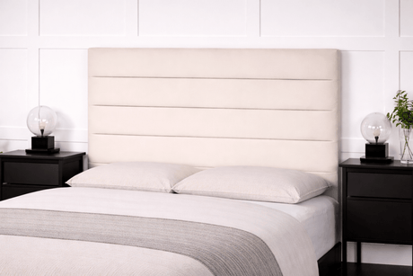 Bedroom with a bed featuring a beige upholstered headboard, white bedding, and black nightstands.